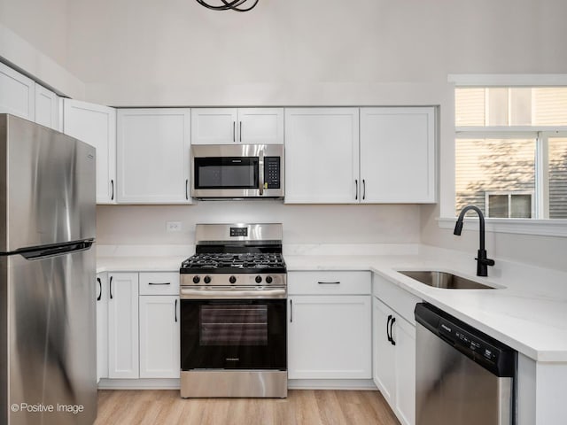 2804 River Bend Ln, Plainfield, IL 60586 - kitchen featuring appliances with stainless steel finishes, white cabinets, light wood-type flooring, and light stone countertops