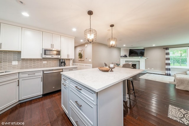 1715 Chesterfield Ave, Glen Ellyn, IL 60137 - kitchen featuring stainless steel appliances, open floor plan, dark wood-style flooring, a baseboard heating unit, and a kitchen bar