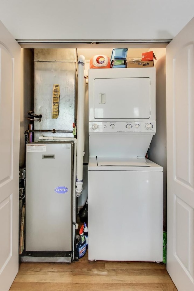 3005 N Clifton Ave Unit 201, Chicago, IL 60657 - laundry area featuring stacked washer / drying machine and light wood-style floors