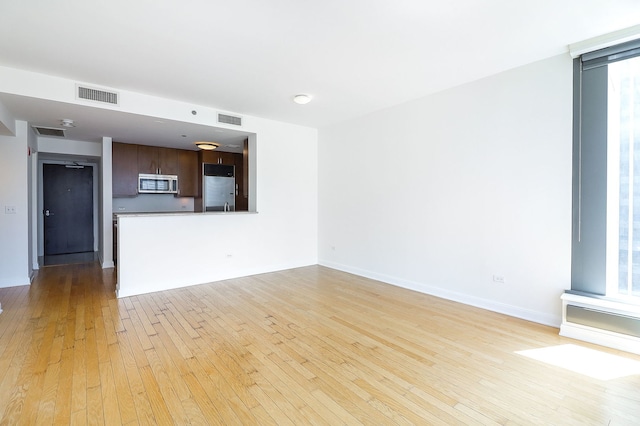 60 E Monroe St Unit 2705, Chicago, IL 60603 - unfurnished living room featuring light wood-type flooring and baseboards
