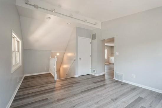 3131 N Odell Ave, Chicago, IL 60707 - empty room with vaulted ceiling, wood finished floors, and rail lighting