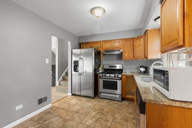 225 S Willow St, Glenwood, IL 60425 - kitchen featuring stainless steel appliances, under cabinet range hood, light stone counters, and brown cabinetry
