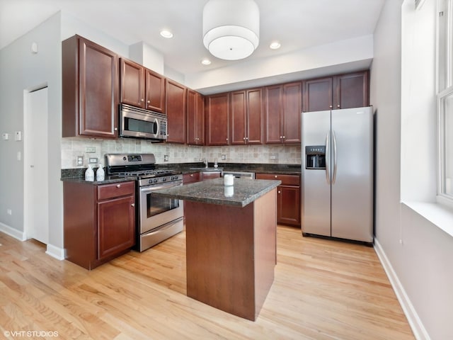 3607 N Bosworth Ave Unit 3, Chicago, IL 60613 - kitchen featuring appliances with stainless steel finishes, light wood-style flooring, decorative backsplash, a kitchen island, and recessed lighting