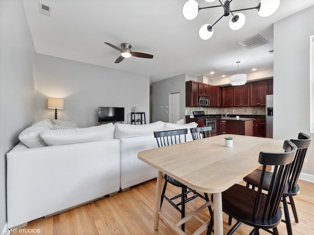 3607 N Bosworth Ave Unit 3, Chicago, IL 60613 - dining room with light wood-style flooring, ceiling fan, and a chandelier