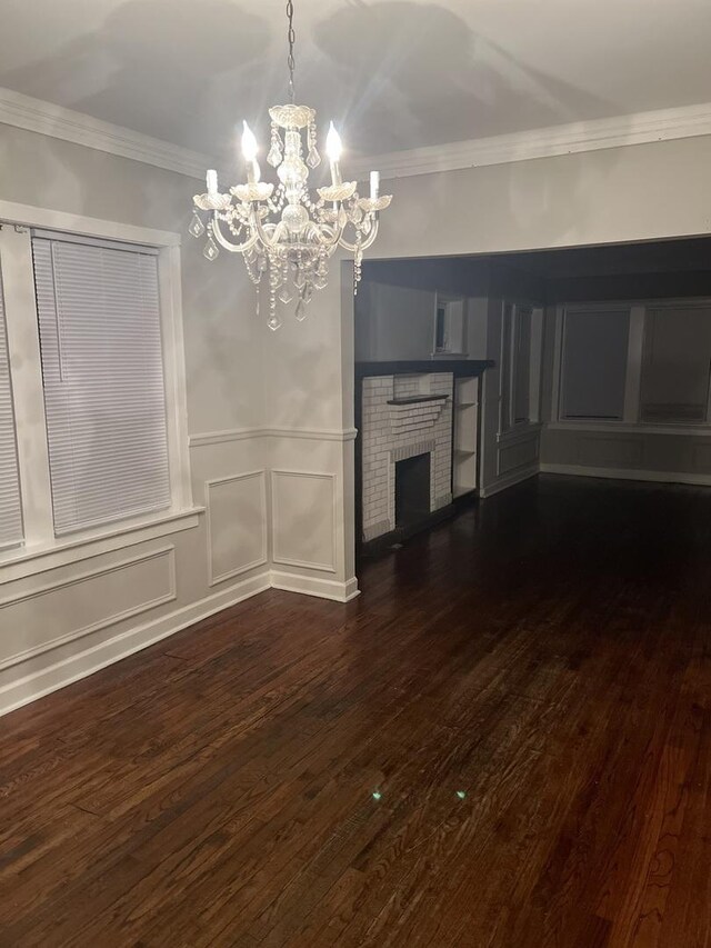 8005 S Blackstone Ave, Chicago, IL 60619 - unfurnished living room featuring a decorative wall, a chandelier, wood finished floors, ornamental molding, and a fireplace