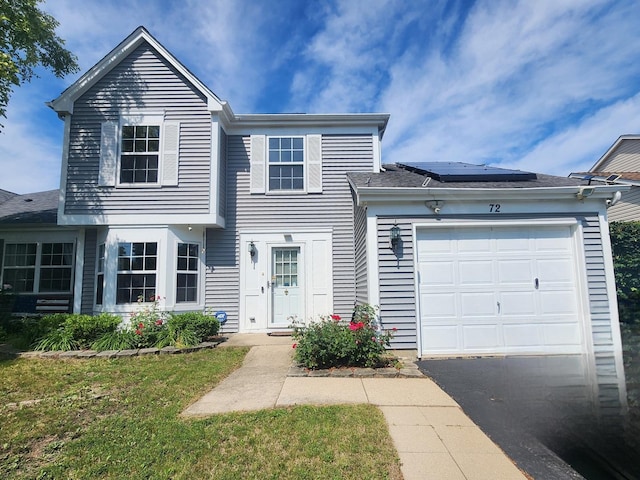 72 Wilton Ln, Mundelein, IL 60060 - view of front of house with an attached garage, roof mounted solar panels, asphalt driveway, and a front yard