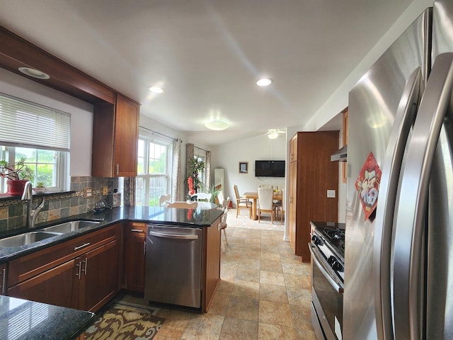 72 Wilton Ln, Mundelein, IL 60060 - kitchen with stainless steel appliances, backsplash, light stone finish floors, a peninsula, and dark stone counters