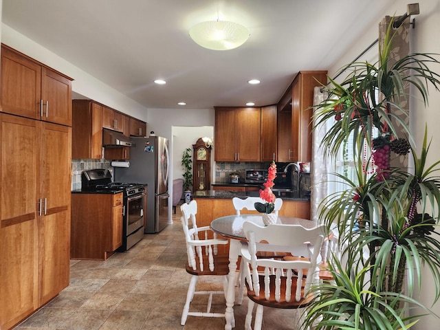 72 Wilton Ln, Mundelein, IL 60060 - kitchen featuring appliances with stainless steel finishes, under cabinet range hood, decorative backsplash, dark countertops, and recessed lighting