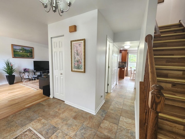 72 Wilton Ln, Mundelein, IL 60060 - corridor with stone tile flooring, stairway, and a chandelier