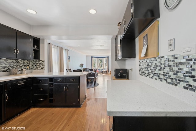 3012 N Nottingham Ave, Chicago, IL 60634 - kitchen featuring dark cabinetry, a peninsula, open shelves, light wood finished floors, and tasteful backsplash