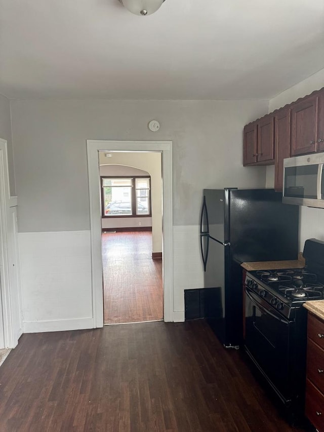 118 Wilcox Ave, Elgin, IL 60123 - kitchen featuring stainless steel microwave, black gas stove, and dark wood-style floors