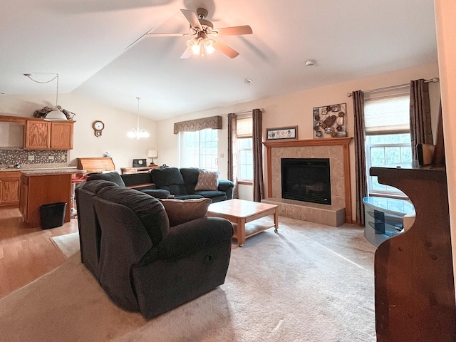 967 Brown Dr, Momence, IL 60954 - living room featuring vaulted ceiling, ceiling fan, a tiled fireplace, and light carpet