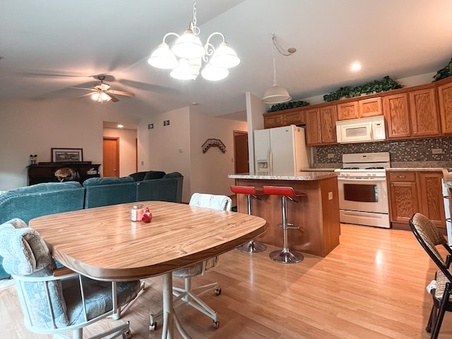 967 Brown Dr, Momence, IL 60954 - dining space featuring light wood-style floors, a chandelier, lofted ceiling, and ceiling fan
