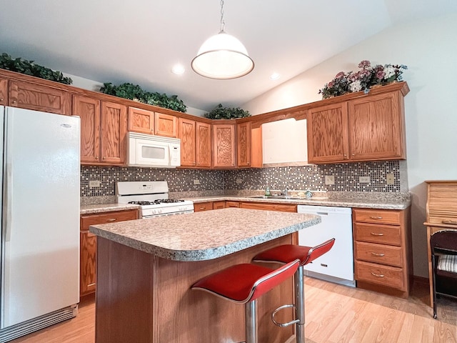 967 Brown Dr, Momence, IL 60954 - kitchen featuring white appliances, vaulted ceiling, light wood-style flooring, backsplash, and a kitchen island