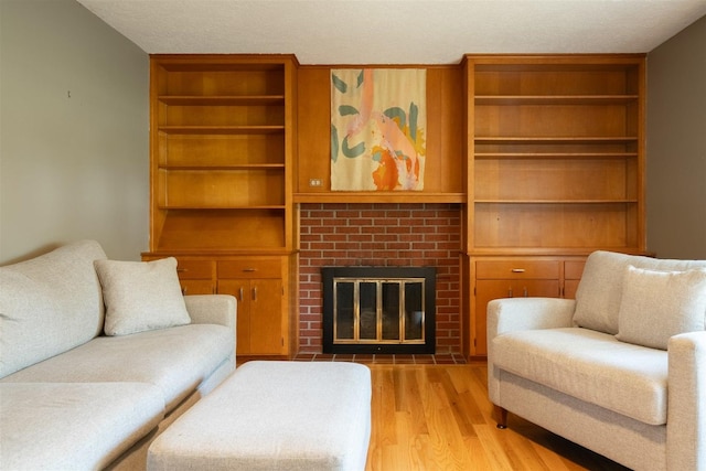 14 Grandview Dr, Normal, IL 61761 - living room featuring light wood-type flooring, a fireplace, built in features, and a textured ceiling