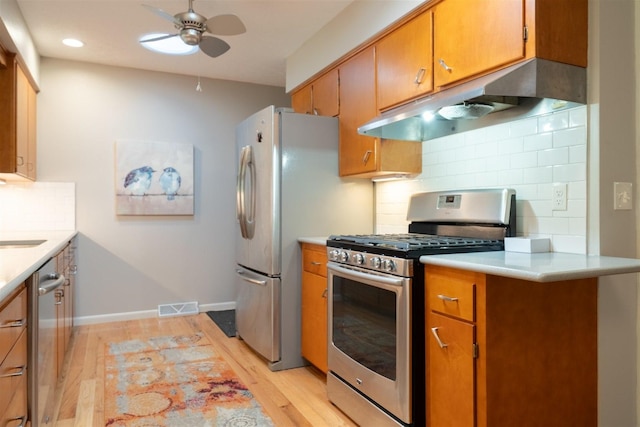 14 Grandview Dr, Normal, IL 61761 - kitchen with stainless steel appliances, under cabinet range hood, ceiling fan, light wood finished floors, and backsplash