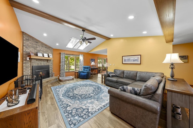 541 Donald St, Hinckley, IL 60520 - living room featuring a ceiling fan, wood finished floors, a brick fireplace, and a skylight