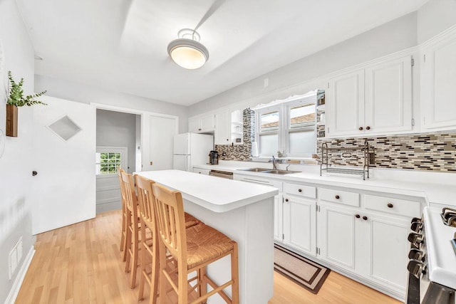 3052 W 100th St, Evergreen Park, IL 60805 - kitchen featuring appliances with stainless steel finishes, tasteful backsplash, a kitchen breakfast bar, a center island, and light countertops