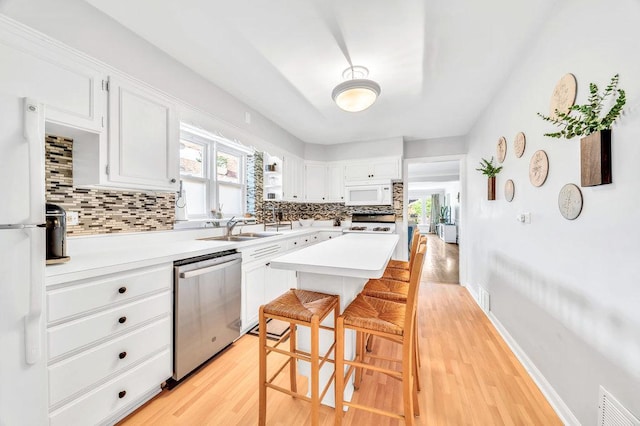3052 W 100th St, Evergreen Park, IL 60805 - kitchen with white appliances, decorative backsplash, light countertops, and light wood-style flooring