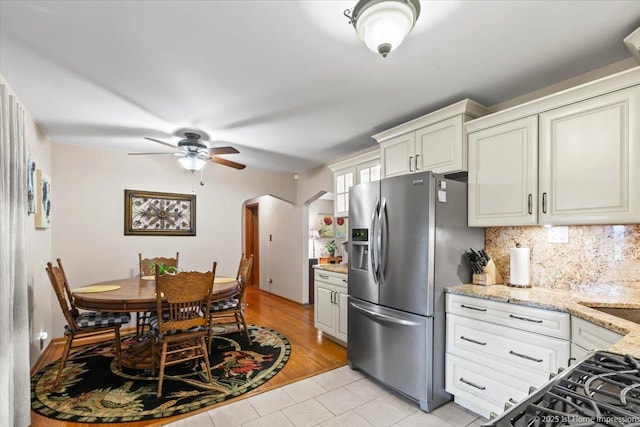 8011 Lawler Ave, Burbank, IL 60459 - kitchen featuring stainless steel refrigerator with ice dispenser, light tile patterned floors, a ceiling fan, decorative backsplash, and light stone counters