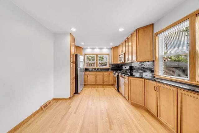10817 S Kenneth Ave, Oak Lawn, IL 60453 - kitchen featuring appliances with stainless steel finishes, light wood finished floors, dark countertops, decorative backsplash, and recessed lighting