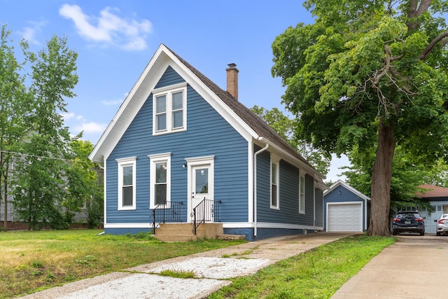444 Villa St, Elgin, IL 60120 - view of front facade with concrete driveway, a chimney, an outbuilding, a detached garage, and a front lawn