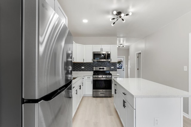 444 Villa St, Elgin, IL 60120 - kitchen with appliances with stainless steel finishes, tasteful backsplash, light wood-style floors, a center island, and white cabinetry