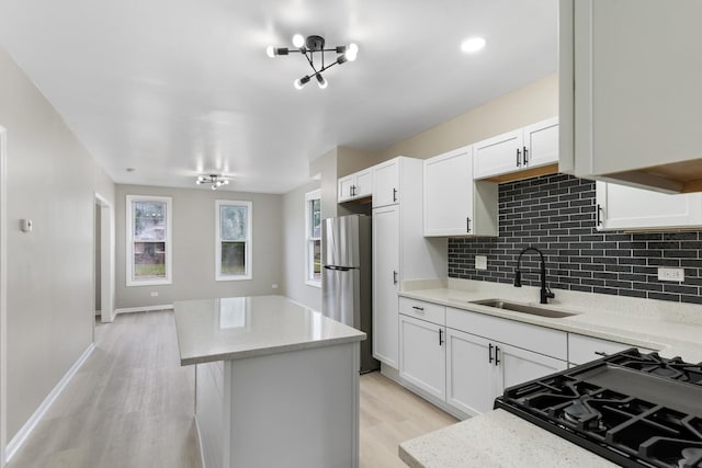 444 Villa St, Elgin, IL 60120 - kitchen with freestanding refrigerator, a kitchen island, decorative backsplash, light wood-type flooring, and white cabinets