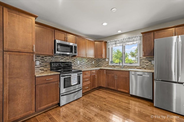 404 Kensington Dr, Mchenry, IL 60050 - kitchen with appliances with stainless steel finishes, wood finished floors, decorative backsplash, light stone countertops, and recessed lighting
