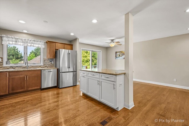 404 Kensington Dr, Mchenry, IL 60050 - kitchen with appliances with stainless steel finishes, a ceiling fan, tasteful backsplash, brown cabinets, and recessed lighting