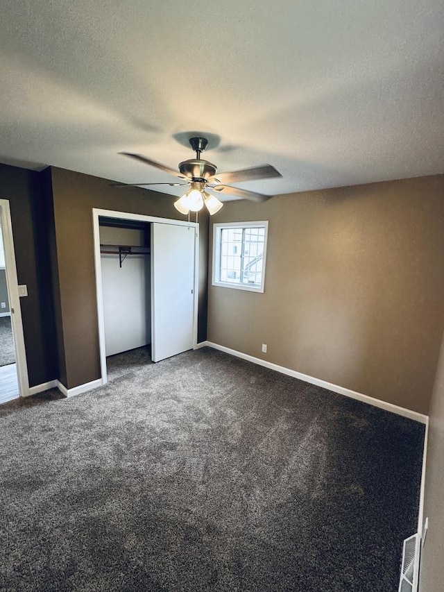 5907 Kirkwood Dr, Rockford, IL 61109 - unfurnished bedroom with dark colored carpet, a closet, a textured ceiling, and a ceiling fan