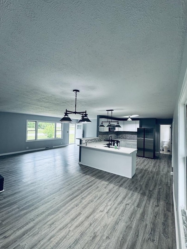 5907 Kirkwood Dr, Rockford, IL 61109 - unfurnished living room featuring dark wood-style flooring and a textured ceiling