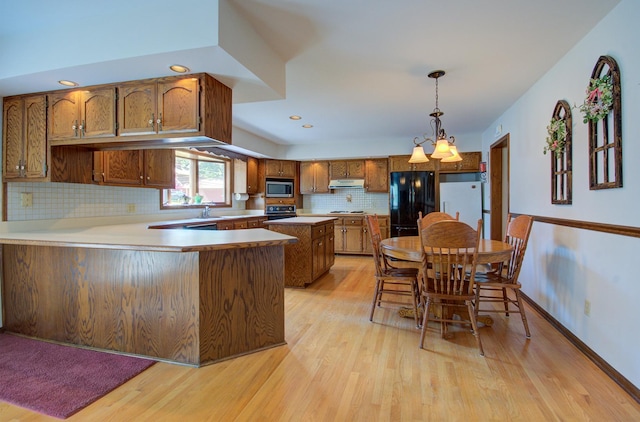900 Mason Ave, Joliet, IL 60435 - kitchen featuring stainless steel microwave, brown cabinets, freestanding refrigerator, a peninsula, and light wood finished floors