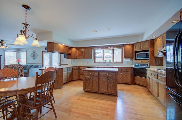 900 Mason Ave, Joliet, IL 60435 - kitchen with black appliances, plenty of natural light, a kitchen island, brown cabinetry, and recessed lighting