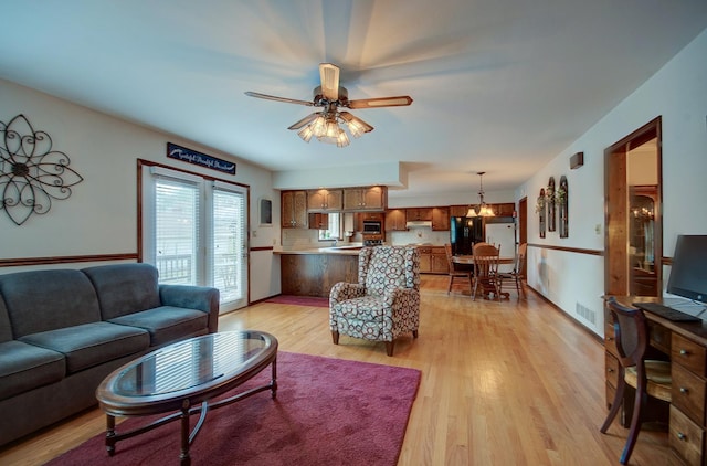 900 Mason Ave, Joliet, IL 60435 - living room with light wood-style flooring, a ceiling fan, and a chandelier