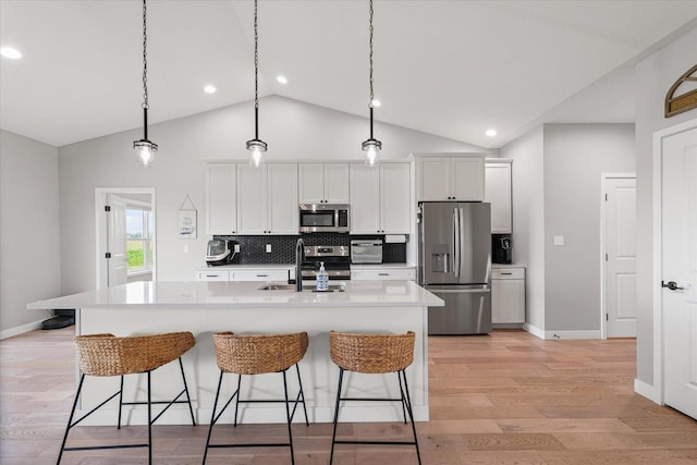 3610 Freedom Blvd, Champaign, IL 61822 - kitchen with stainless steel appliances, a breakfast bar area, light wood finished floors, recessed lighting, and high vaulted ceiling