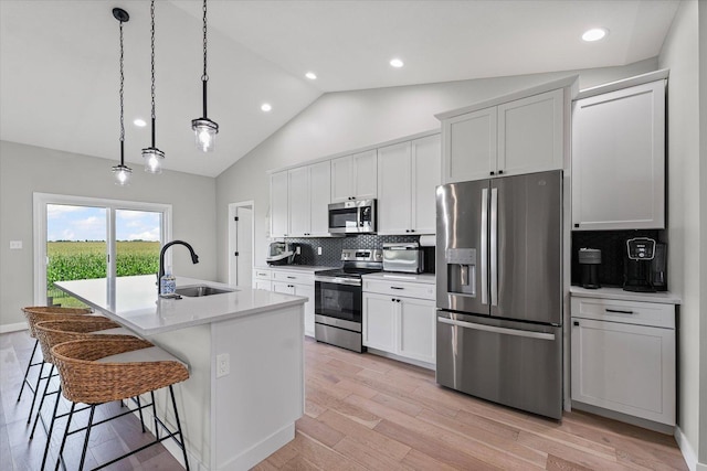 3610 Freedom Blvd, Champaign, IL 61822 - kitchen featuring appliances with stainless steel finishes, decorative backsplash, a center island with sink, a kitchen bar, and white cabinets