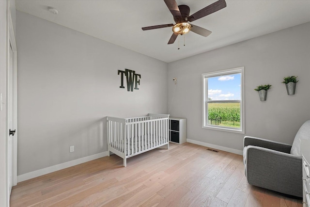 3610 Freedom Blvd, Champaign, IL 61822 - bedroom featuring light wood-style floors, a crib, and ceiling fan
