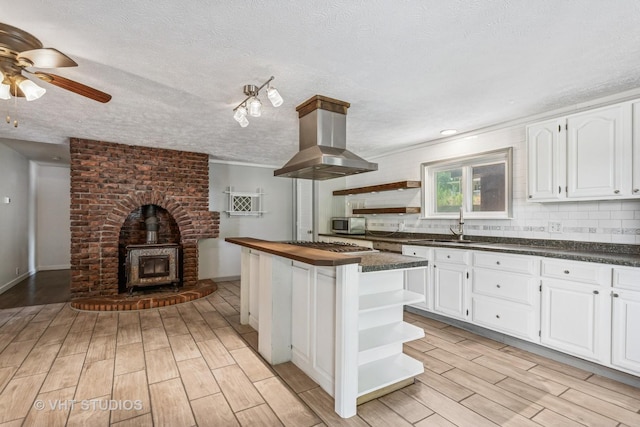 29625 N Readman Ln, Wilmington, IL 60481 - kitchen with open shelves, ceiling fan, island exhaust hood, white cabinets, and light wood finished floors