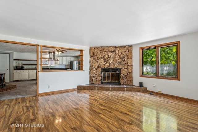 29625 N Readman Ln, Wilmington, IL 60481 - unfurnished living room featuring wood finished floors and a stone fireplace
