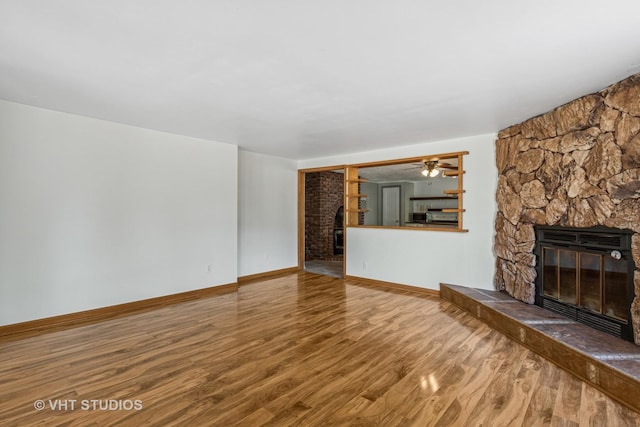 29625 N Readman Ln, Wilmington, IL 60481 - unfurnished living room with a stone fireplace, wood finished floors, and ceiling fan