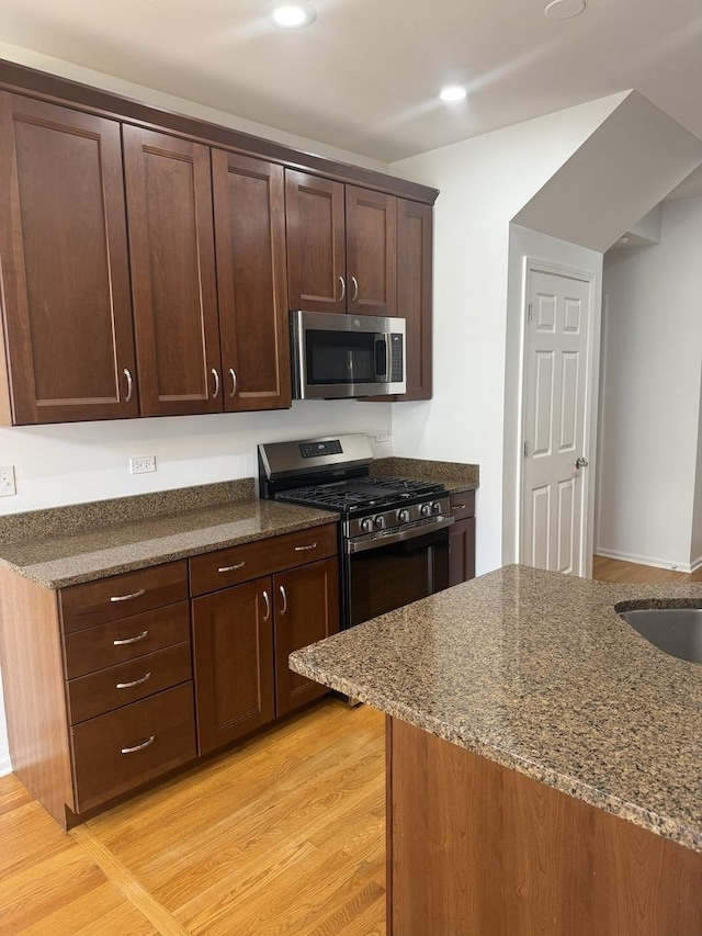 1659 Windward Ct, Naperville, IL 60563 - kitchen with appliances with stainless steel finishes, dark stone countertops, dark brown cabinetry, recessed lighting, and light wood-type flooring