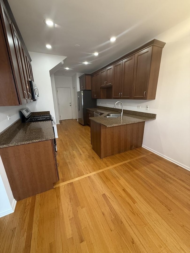 1659 Windward Ct, Naperville, IL 60563 - kitchen with a peninsula, appliances with stainless steel finishes, light wood finished floors, dark stone counters, and recessed lighting