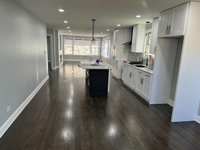 12152 S Union Ave, Chicago, IL 60628 - kitchen with light countertops, a kitchen island, white cabinetry, dark wood-type flooring, and recessed lighting