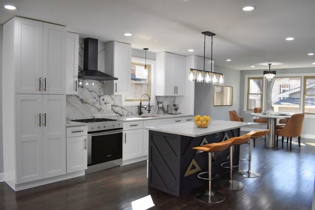 12152 S Union Ave, Chicago, IL 60628 - kitchen with wall chimney exhaust hood, white range with gas cooktop, decorative backsplash, a kitchen island, and dark wood-style flooring
