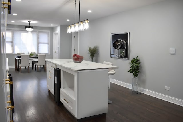 12152 S Union Ave, Chicago, IL 60628 - kitchen featuring dark wood-style flooring, a center island, recessed lighting, light stone counters, and pendant lighting