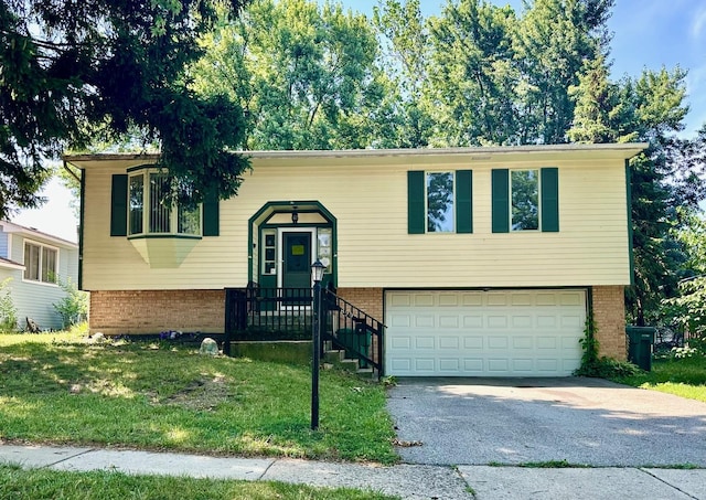 899 Carl Ave, Elgin, IL 60120 - raised ranch featuring brick siding, an attached garage, driveway, and a front yard
