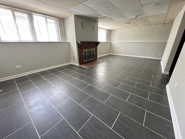 899 Carl Ave, Elgin, IL 60120 - unfurnished living room featuring a brick fireplace, dark tile patterned flooring, and a paneled ceiling