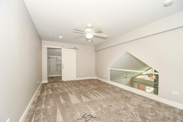 18100 Rita Rd Unit 3B, Tinley Park, IL 60477 - unfurnished bedroom with a barn door, carpet flooring, ceiling fan, and a walk in closet