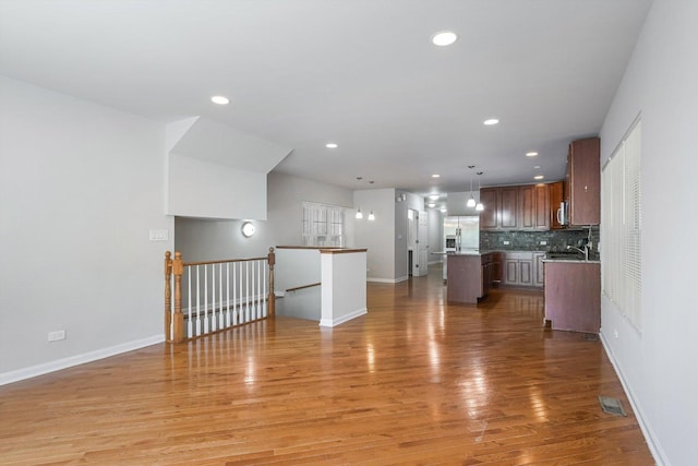2726 W Thomas St, Chicago, IL 60622 - kitchen featuring a center island, open floor plan, light wood-style floors, stainless steel fridge, and backsplash